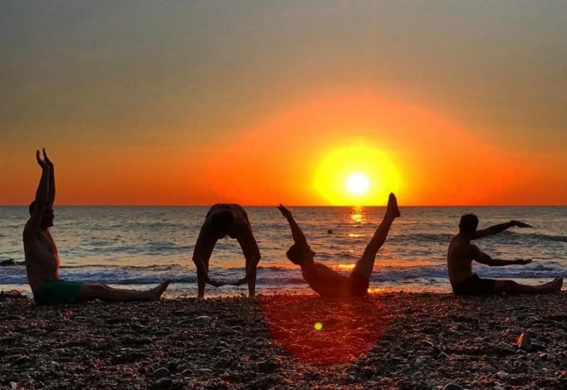 people doing yoga on greystones beach