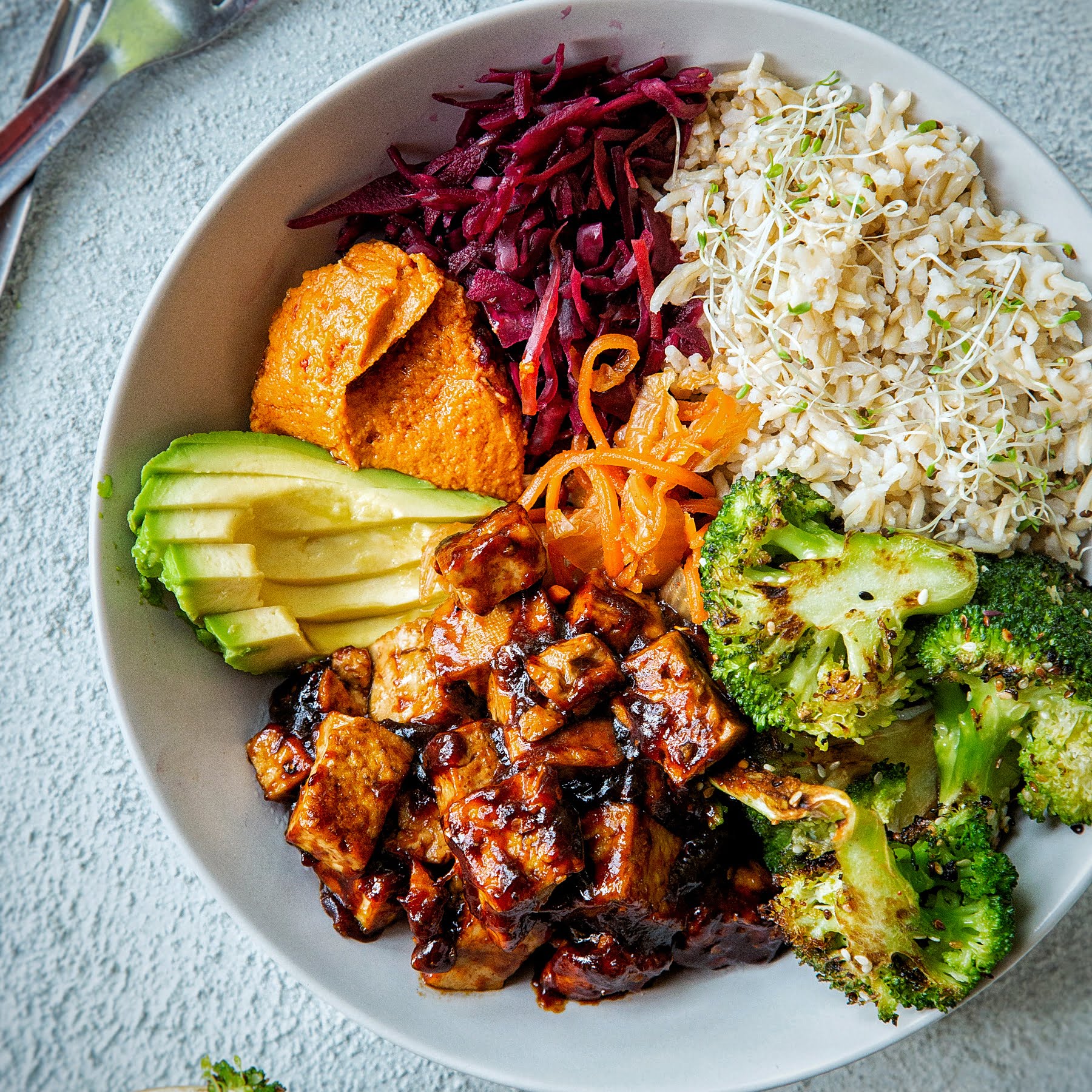 An image of Sticky spicy tofu and charred broccoli buddha bowl