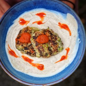 An image of Courgette Fritters with a Red Pepper Pickle Sauce and Tahini Cream