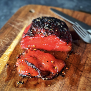 a photo of vegan watermelon tuna steak on wooden board