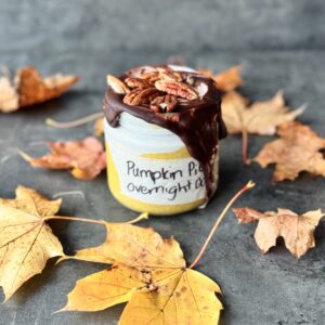 a photo of a jar of Pumpkin Pie Overnight Oats with Maple-Spiced Cream & Chocolate Shell