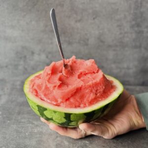 a photo of Watermelon Lime Sorbet served in half of a watermelon