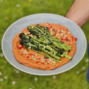 a photo of a plate of Charred Tenderstem Broccoli with Romesco, Tahini Cream & Toasted Pine Nuts