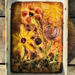 a photo of focaccia pizza with flower design toppings