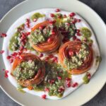 a photo of Carrot Rounds with Tahini Cream, Basil Pesto & Pomegranate