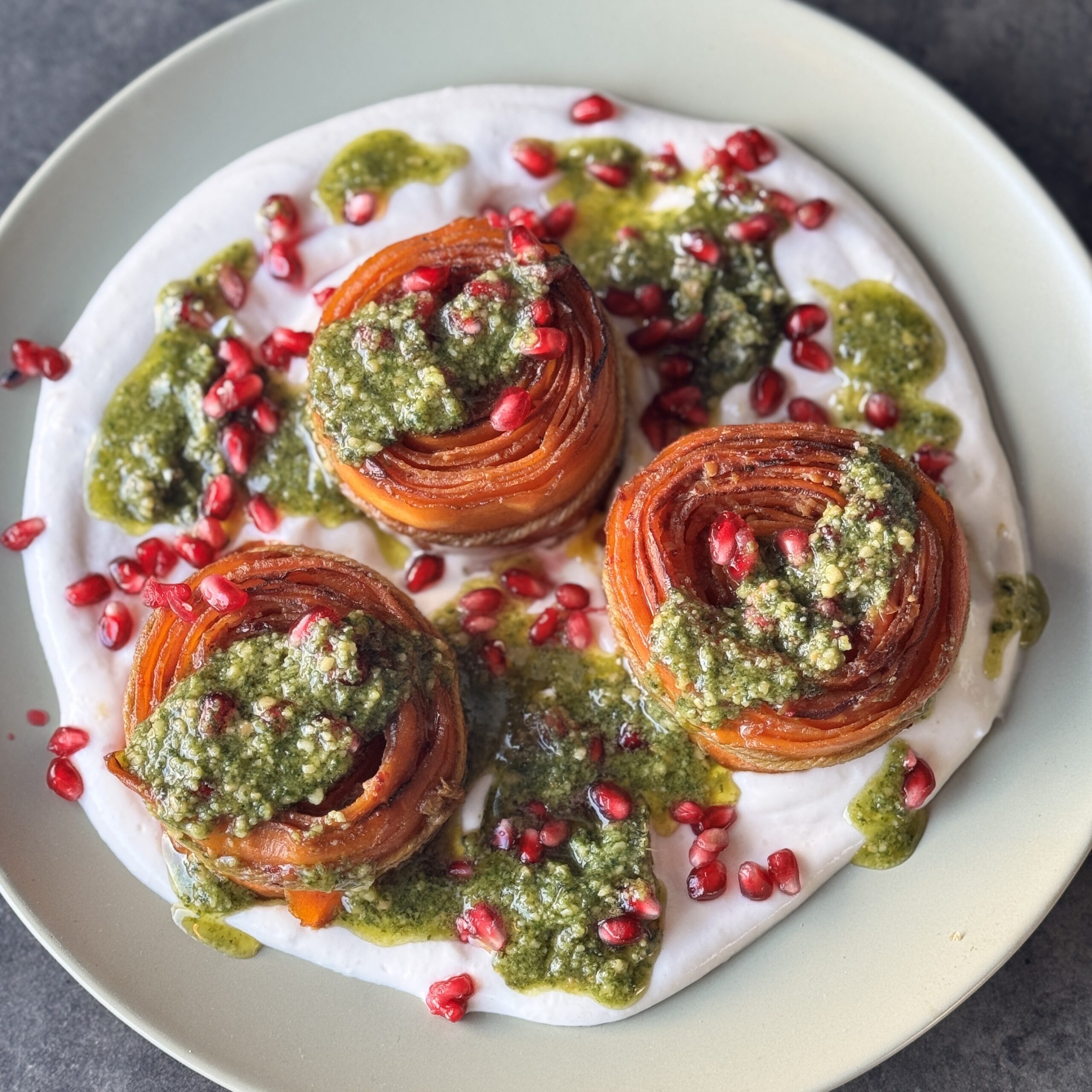 a photo of Carrot Rounds with Tahini Cream, Basil Pesto & Pomegranate